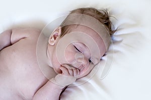 Portrait of a cuteÃÂ 3 month baby, boy or girl, on white background, sucking his finger